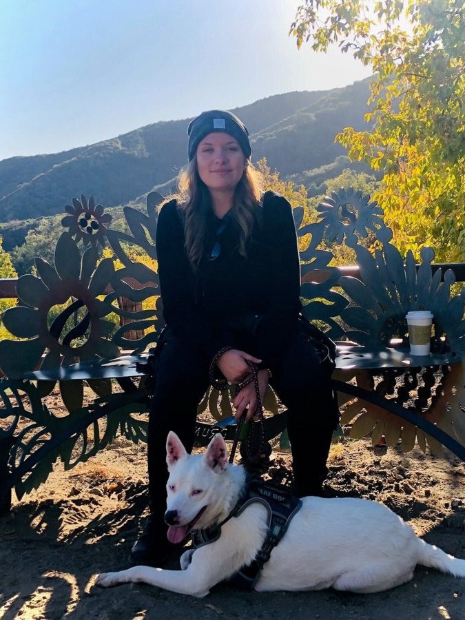 Kat on a bench with a white dog